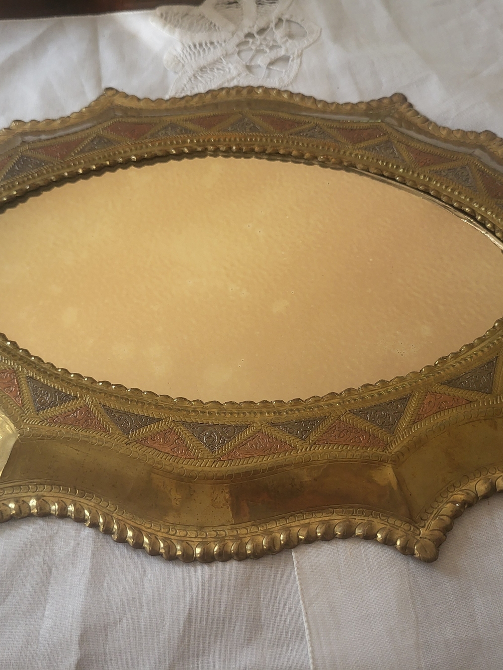 vintage oval brass vanity tray or decorative mirror featuring scalloped edges